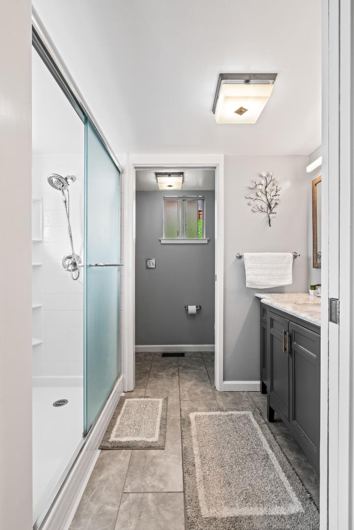 804 Prairie Creek Drive Pacifica, CA 94044 - Photo 27 of 64 a bathroom with a granite countertop sink a mirror and a shower