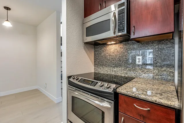 a kitchen with stainless steel appliances granite countertop a sink a refrigerator and a stove