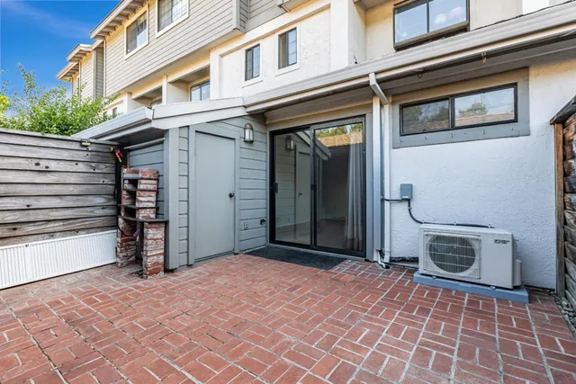a view of a house with wooden stairs and potted plants