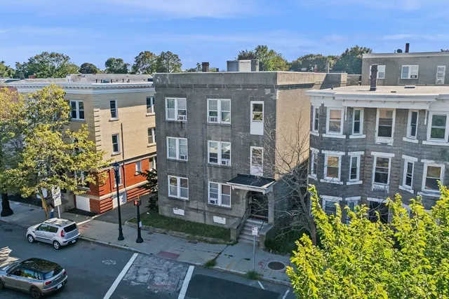 a front view of a residential apartment building with a yard