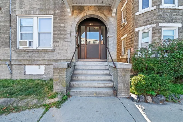 a view of a brick building with potted plants