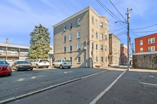 a city street lined with parked cars and buildings