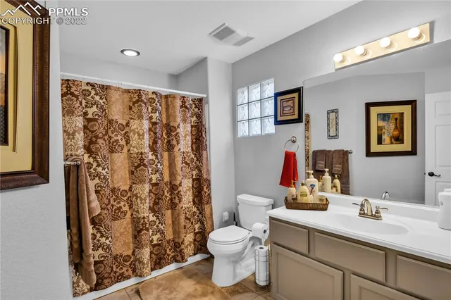 a bathroom with a toilet sink and shower curtain
