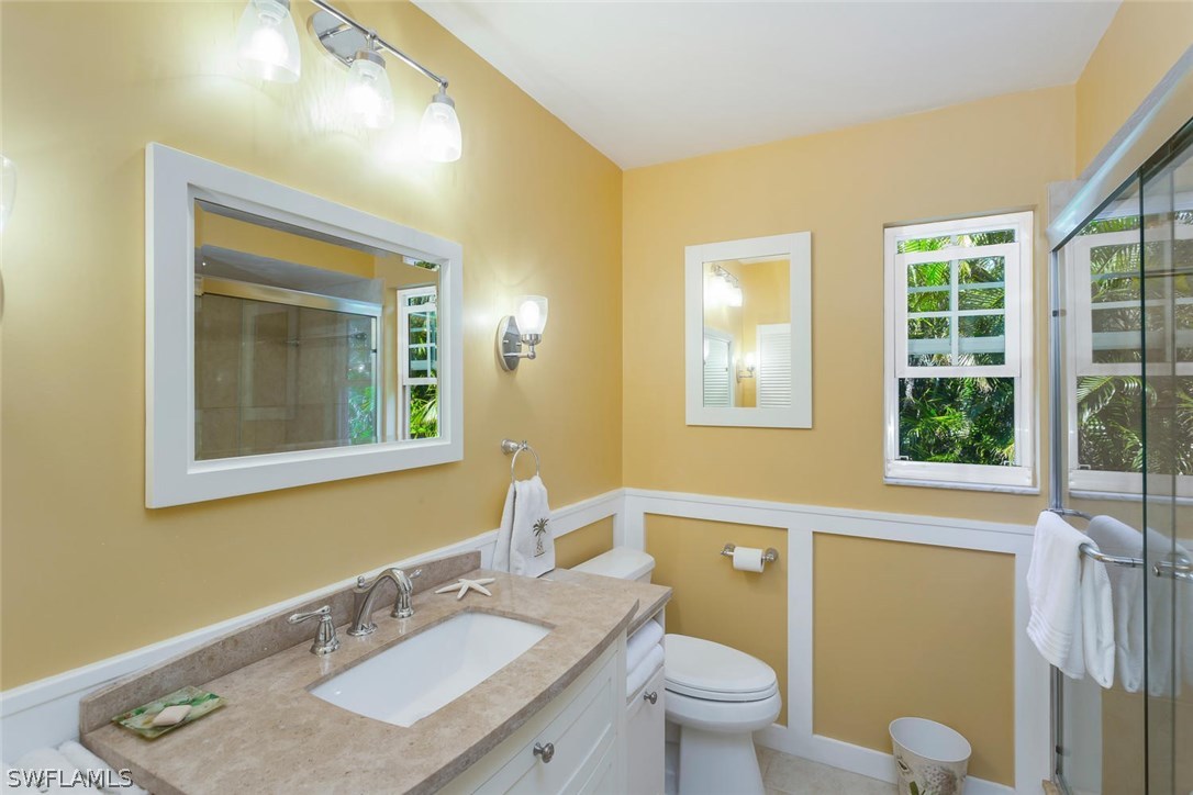1341 Sand Castle Road Sanibel, FL 33957 - Photo 10 of 18 a bathroom with a granite countertop sink toilet and mirror