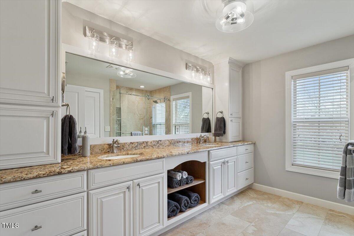 105 Sunstone Drive Cary, NC 27519 - Photo 16 of 25 a spacious bathroom with a granite countertop sink a mirror and a
