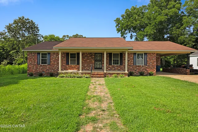 a view of a house with a yard and potted plants