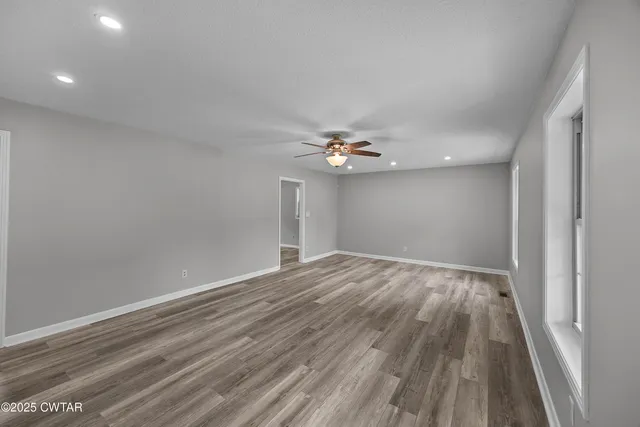 a view of empty room with wooden floor