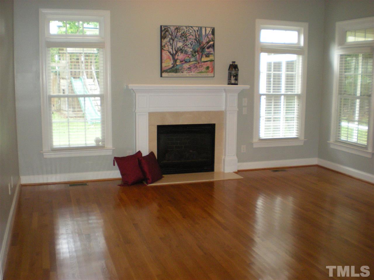 6301 Pleasant Creek Court Raleigh, NC 27613 - Photo 3 of 21 an empty room with wooden floor fireplace and windows