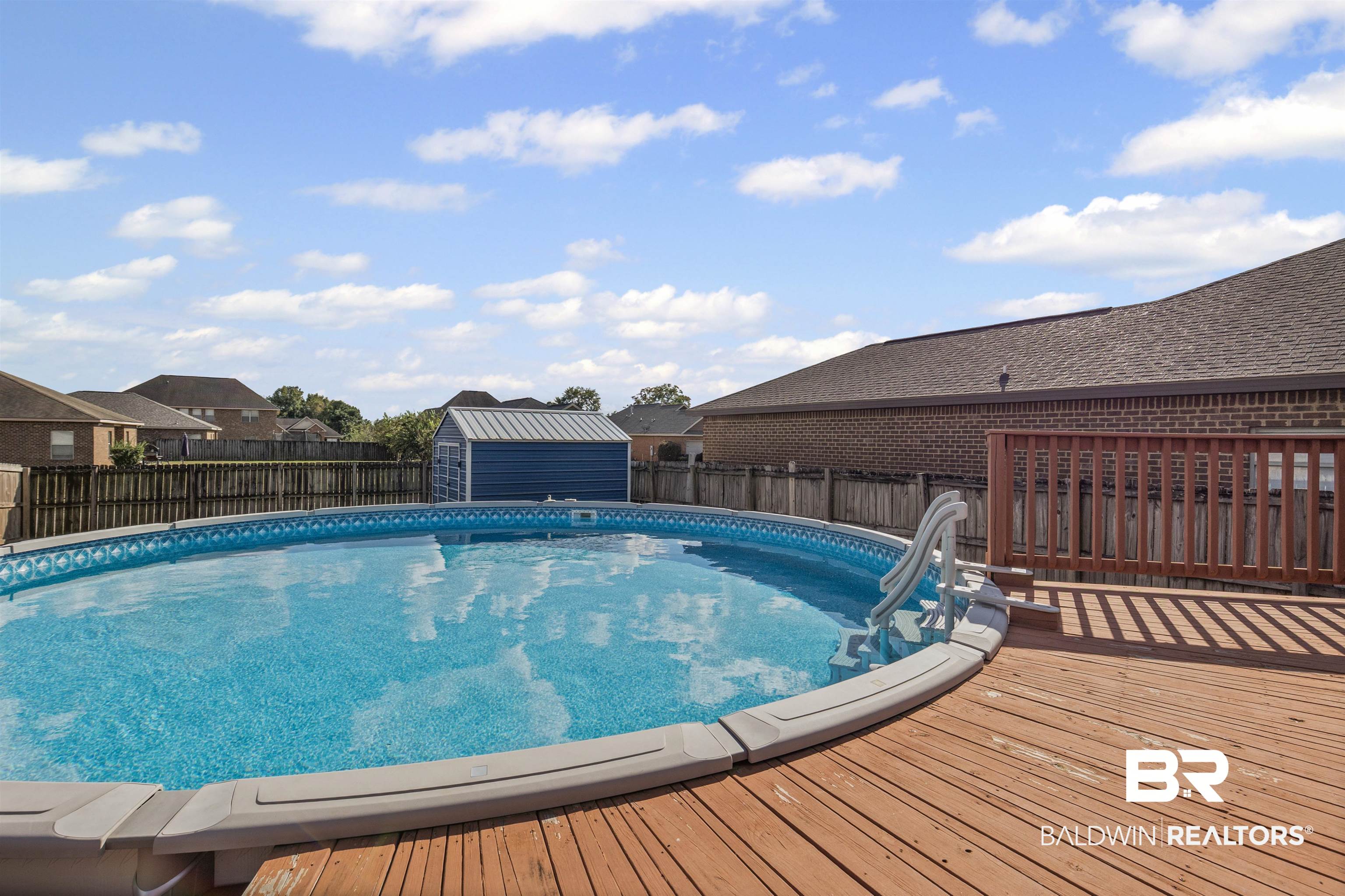 4107 Nottingham Drive Semmes, AL 36575 - Photo 20 of 23 View of swimming pool with a deck, a fenced backyard, and a shed