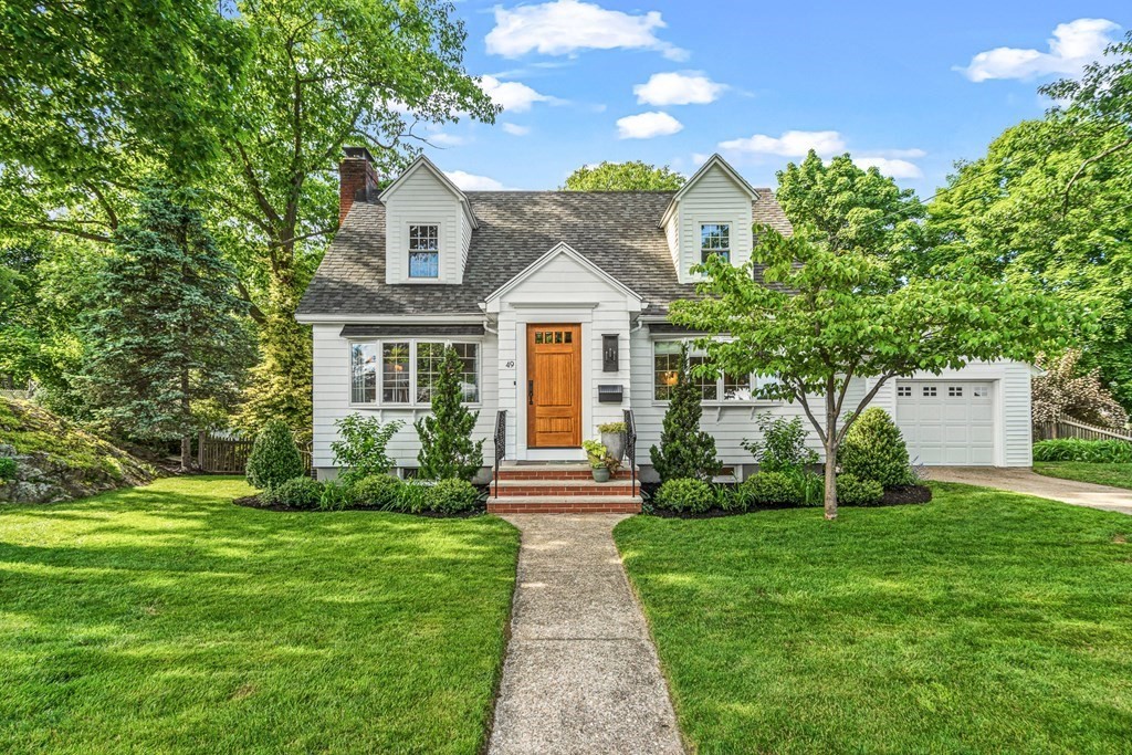 a front view of a house with yard and green space