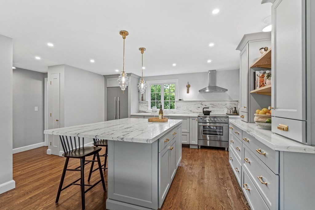 49 Ripley Road Medford, MA 02155 - Photo 7 of 39 a kitchen with stainless steel appliances granite countertop a kitchen island a stove and a wooden floors
