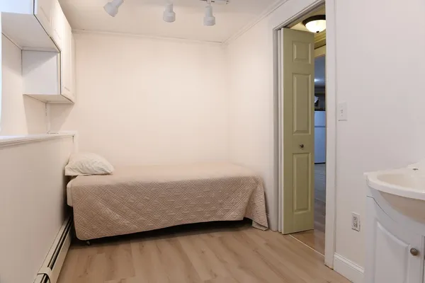 a room with a bed and a wooden floor