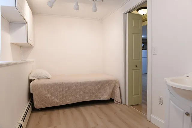a room with a bed and a wooden floor