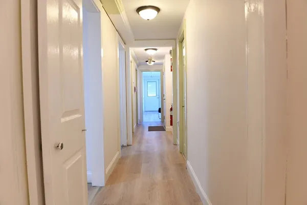 a view of a hallway with wooden floor