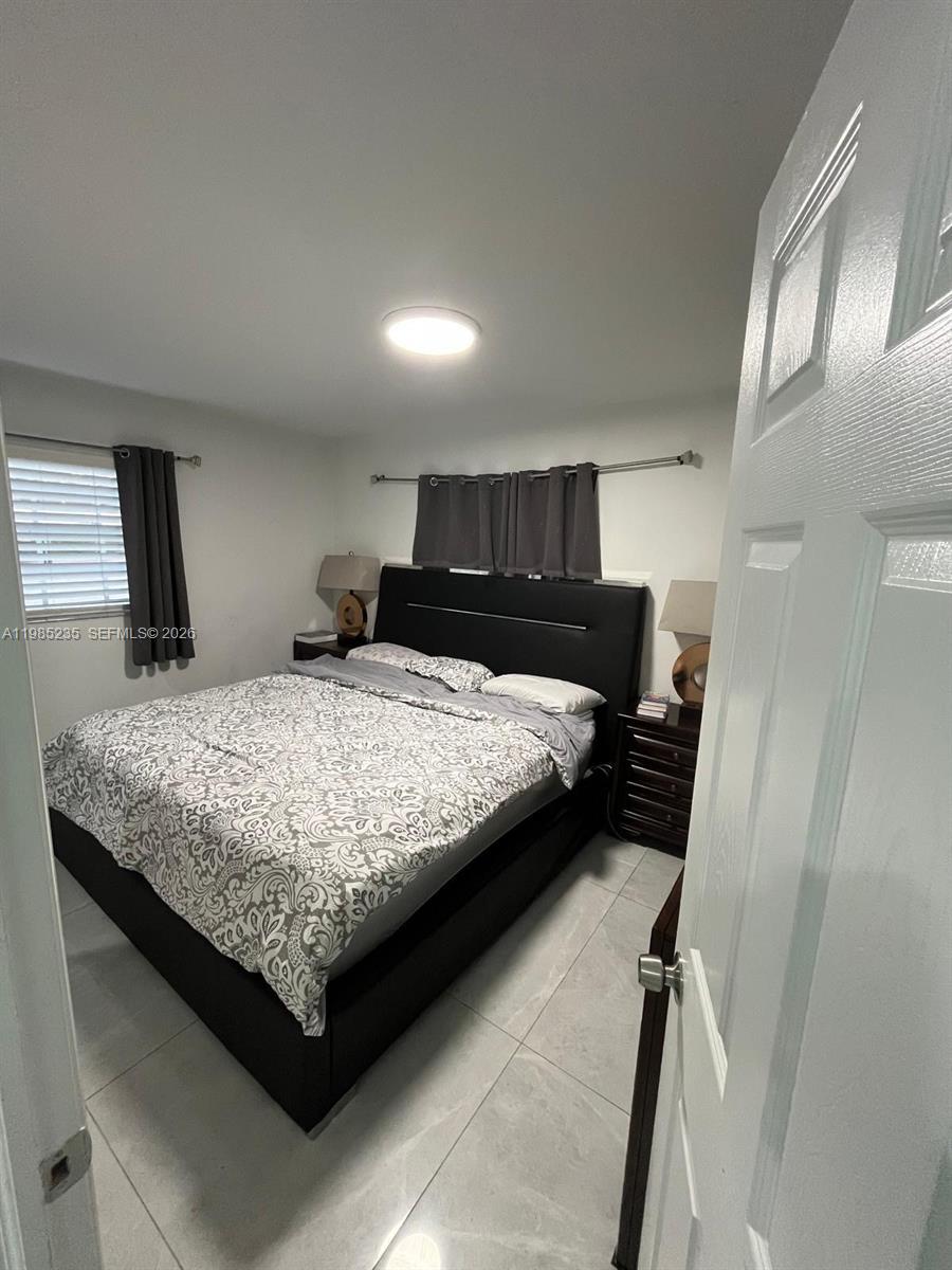 9770 Southwest 13th Terrace Miami, FL 33174 - Photo 6 of 9 a bedroom with a bed and window