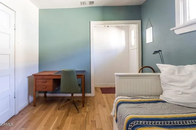 a bedroom with a bed and wooden floor