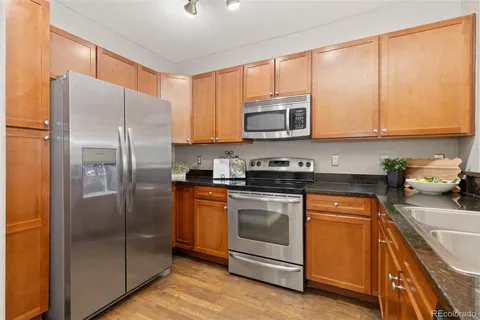 a kitchen with stainless steel appliances granite countertop a refrigerator stove and microwave