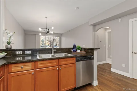 a kitchen with stainless steel appliances granite countertop white cabinets and wooden floor