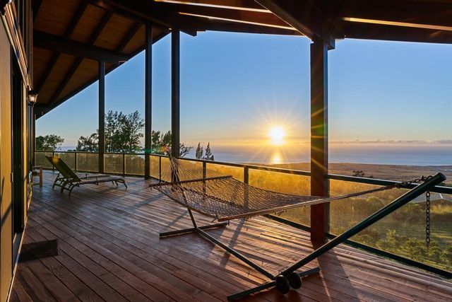 a view of a balcony with wooden floor and seating space