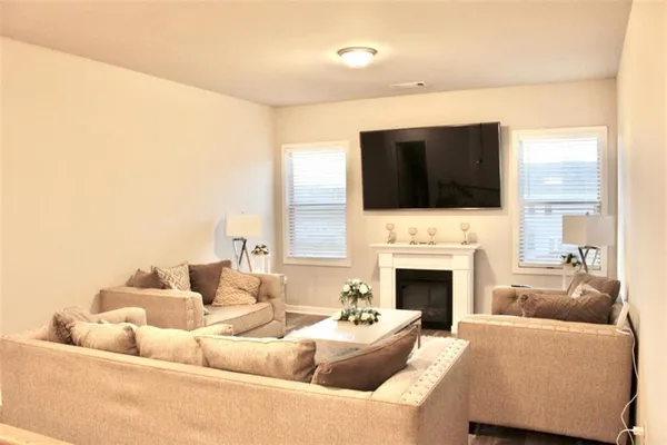 a living room with furniture a flat screen tv a fireplace and a fireplace