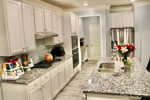 a kitchen with white cabinets and sink