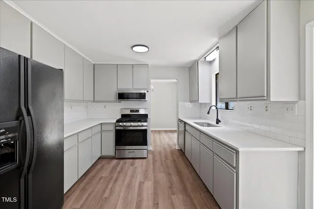 a kitchen with a sink stove and cabinets