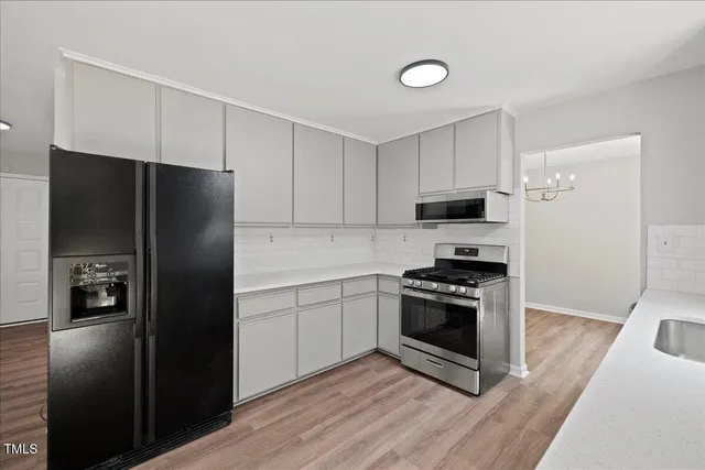 a kitchen with a sink wooden floor and stainless steel appliances