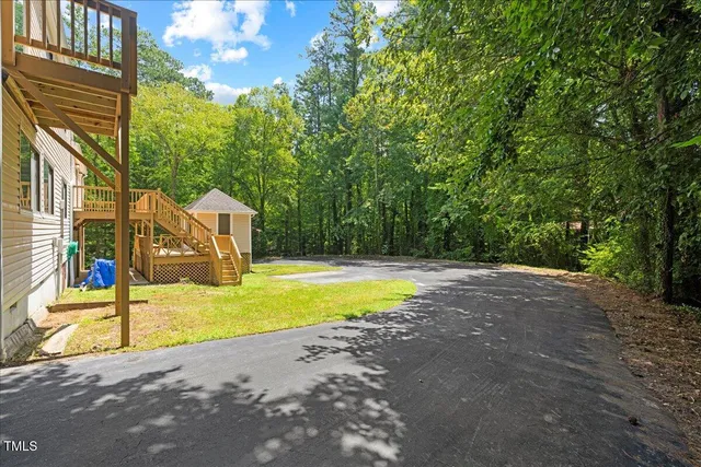 an aerial view of a house with a yard and large trees