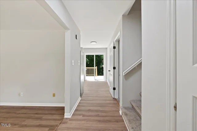 a view of a hallway with wooden floor and staircase