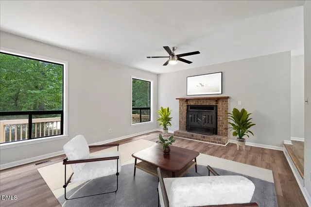 a living room with furniture a large window and a fireplace