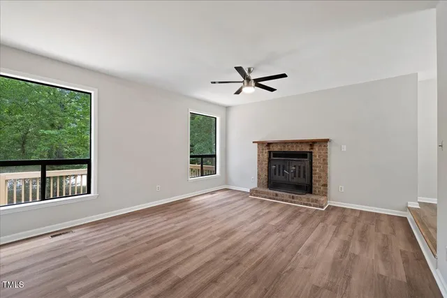 a view of an empty room with a window and fireplace