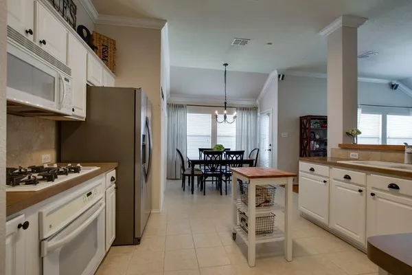 a kitchen with a table chairs refrigerator and cabinets