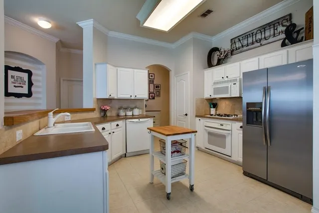a kitchen with white cabinets and stainless steel appliances