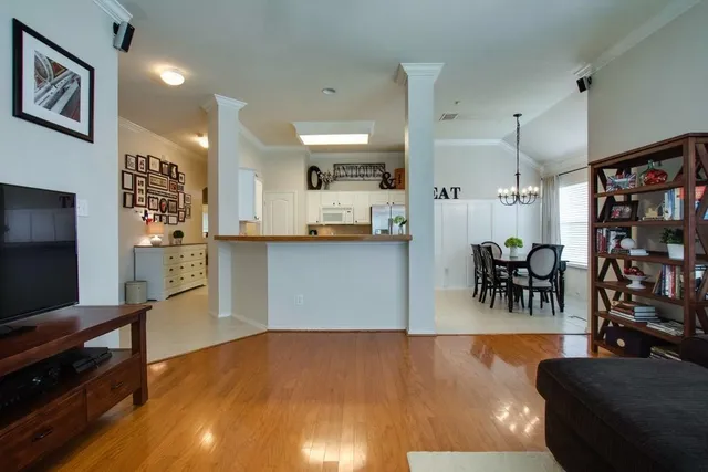 a living room with stainless steel appliances lots of furniture and chandelier