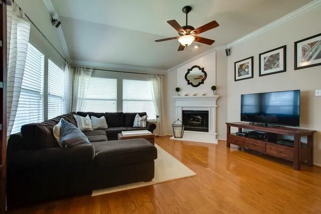a living room with furniture a flat screen tv and a fireplace