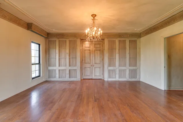 a view of empty room with wooden floor