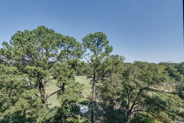 a room with stainless steel appliances kitchen island granite countertop a table chairs and a living room view