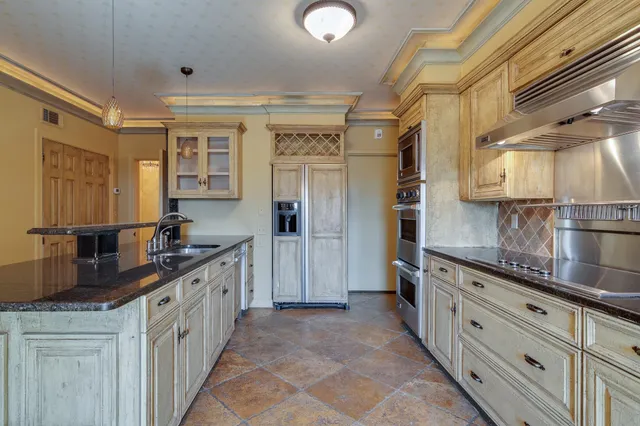 a view of a kitchen with stainless steel appliances granite countertop a stove and a sink