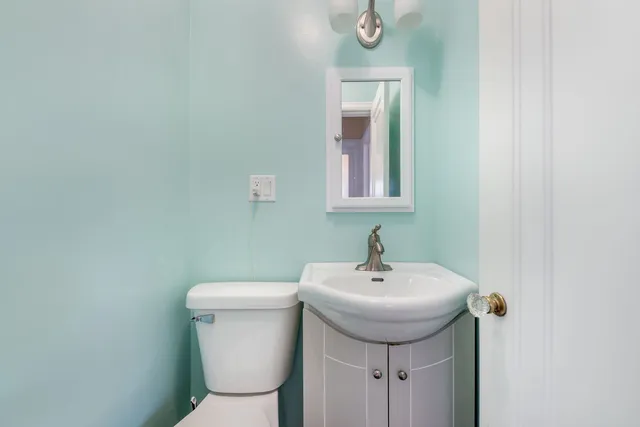 a bathroom with a toilet sink and mirror