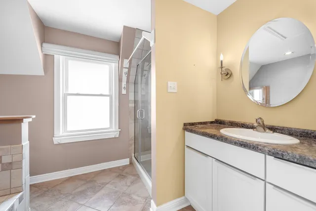 a bathroom with a granite countertop sink a mirror and a window