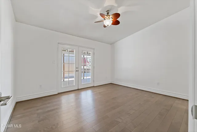 an empty room with painting on the wall and wooden floor