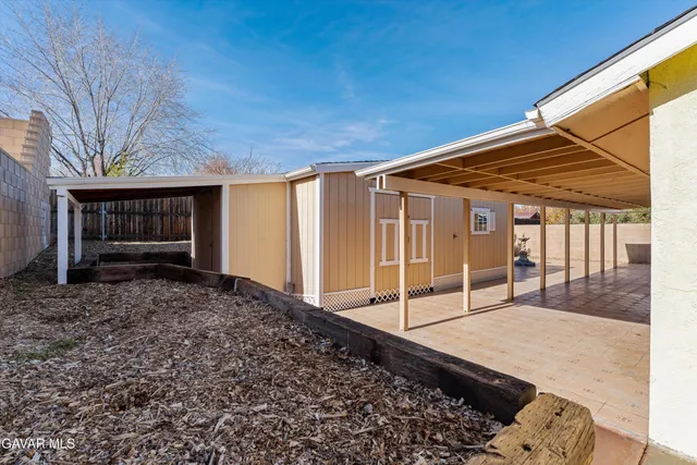 a view of a backyard with wooden fence and large trees