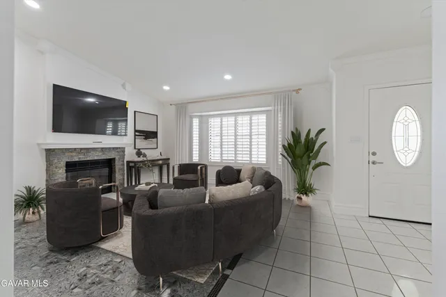 a living room with furniture a fireplace and a flat screen tv
