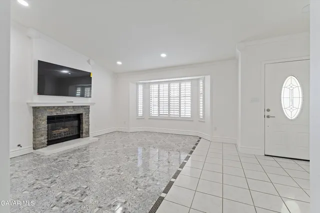 a view of an empty room with a fireplace and a window