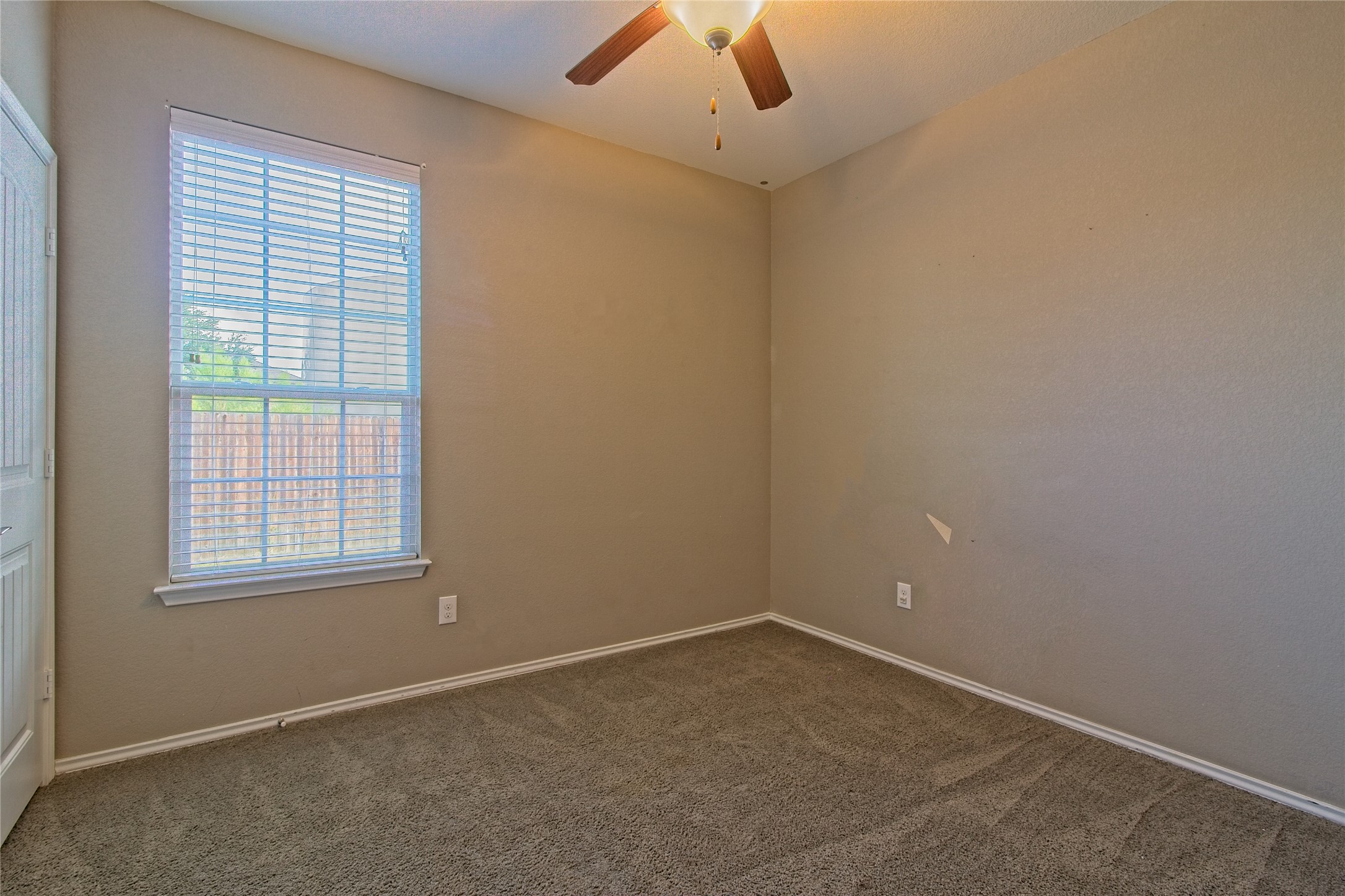 31443 Kingsway Road Georgetown, TX 78628 - Photo 21 of 40 A well-lit bedroom offering a quiet retreat with soft carpet and a window for natural illumination.