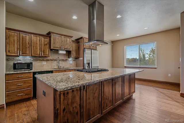 a kitchen with kitchen island a counter top space a sink and stainless steel appliances
