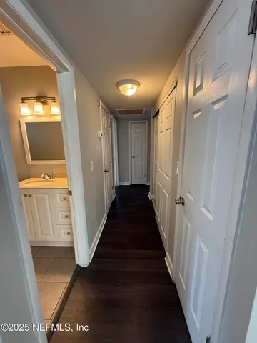 a view of a hallway with wooden floor and staircase