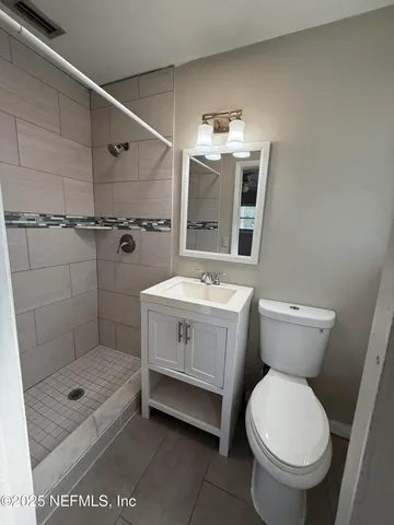 a bathroom with a granite countertop toilet sink and shower