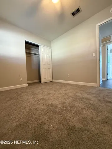 an empty room with closet and windows