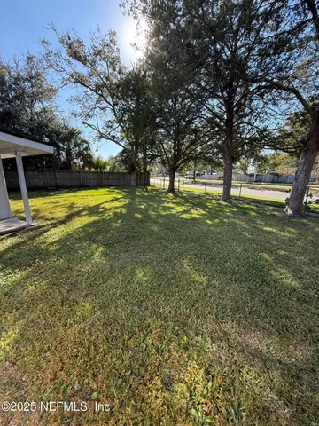 a view of yard with swimming pool and trees